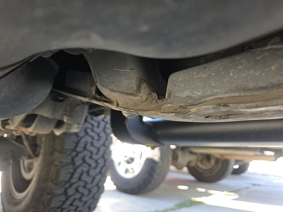 Exhaust and rear suspension seen from beneath a pickup