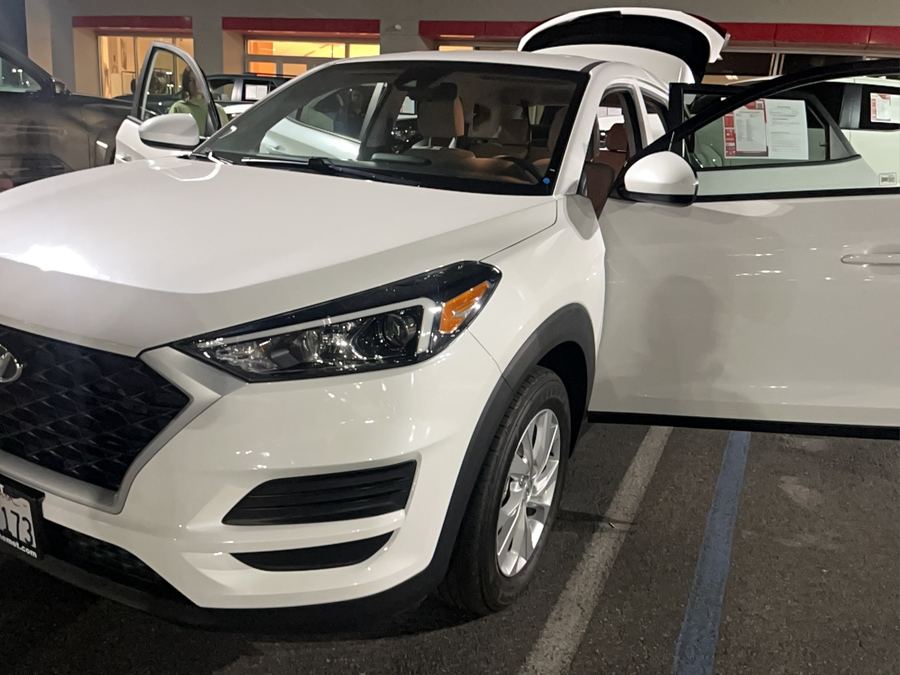 White Hyundai Tucson with its doors open on a dealer lot