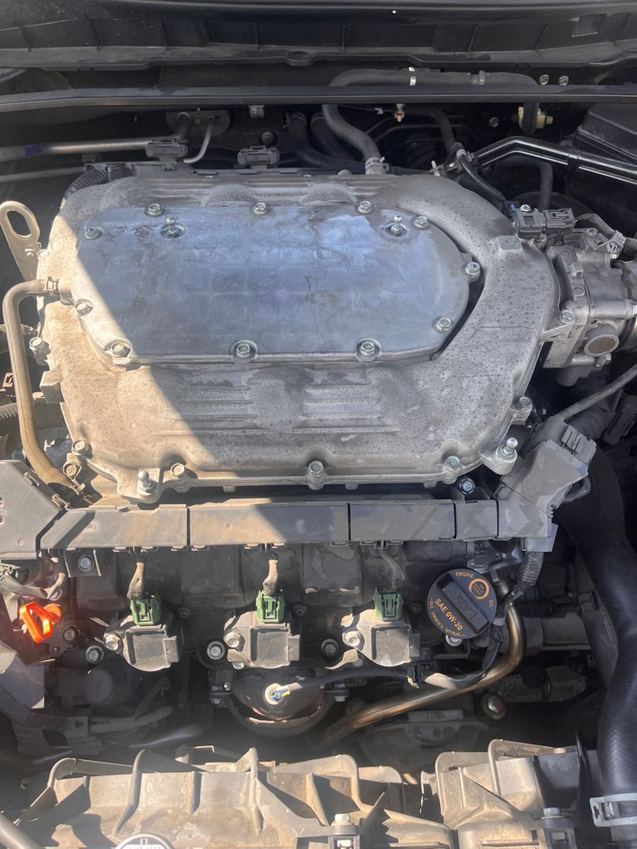 Engine bay of a four-cylinder Honda with the plastic engine cover in place
