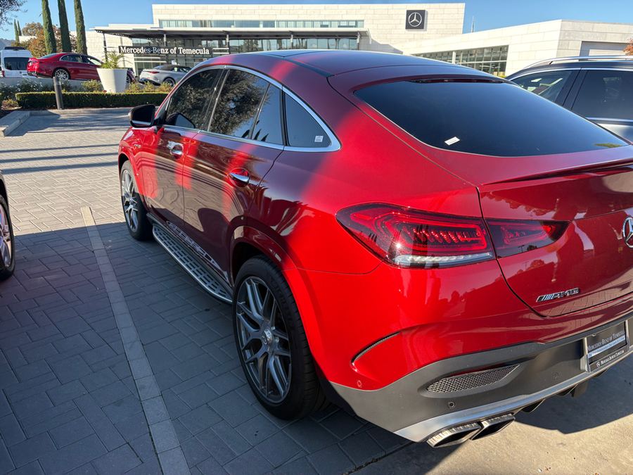 Rear three-quarter view of a red AMG coupe
