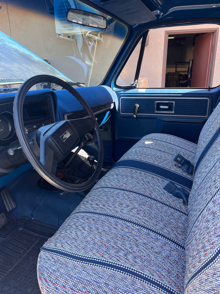 Steering wheel, dashboard and bench seat of a 1970s truck cab