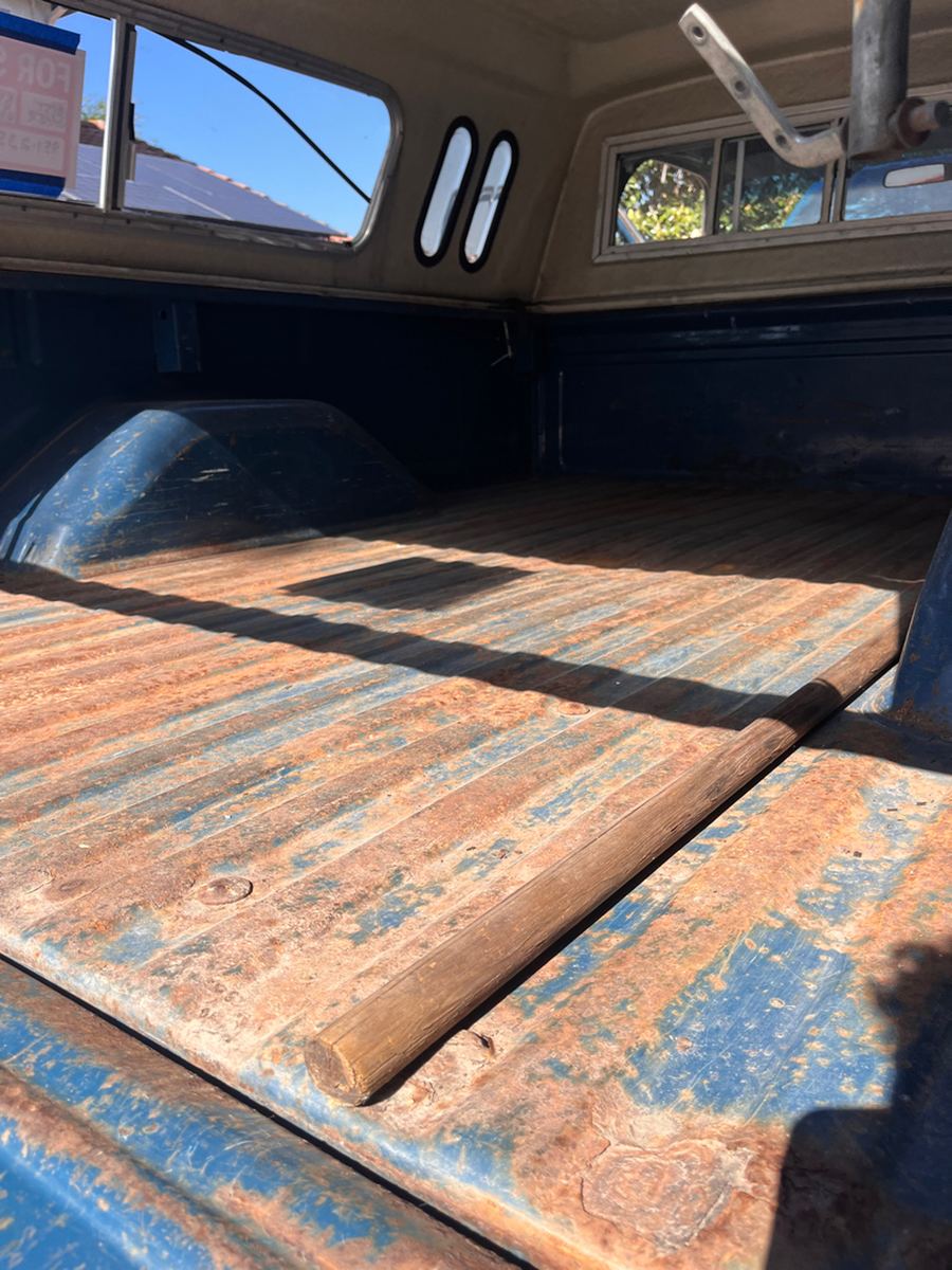 Pickup bed floor of wood and steel with worn blue paint