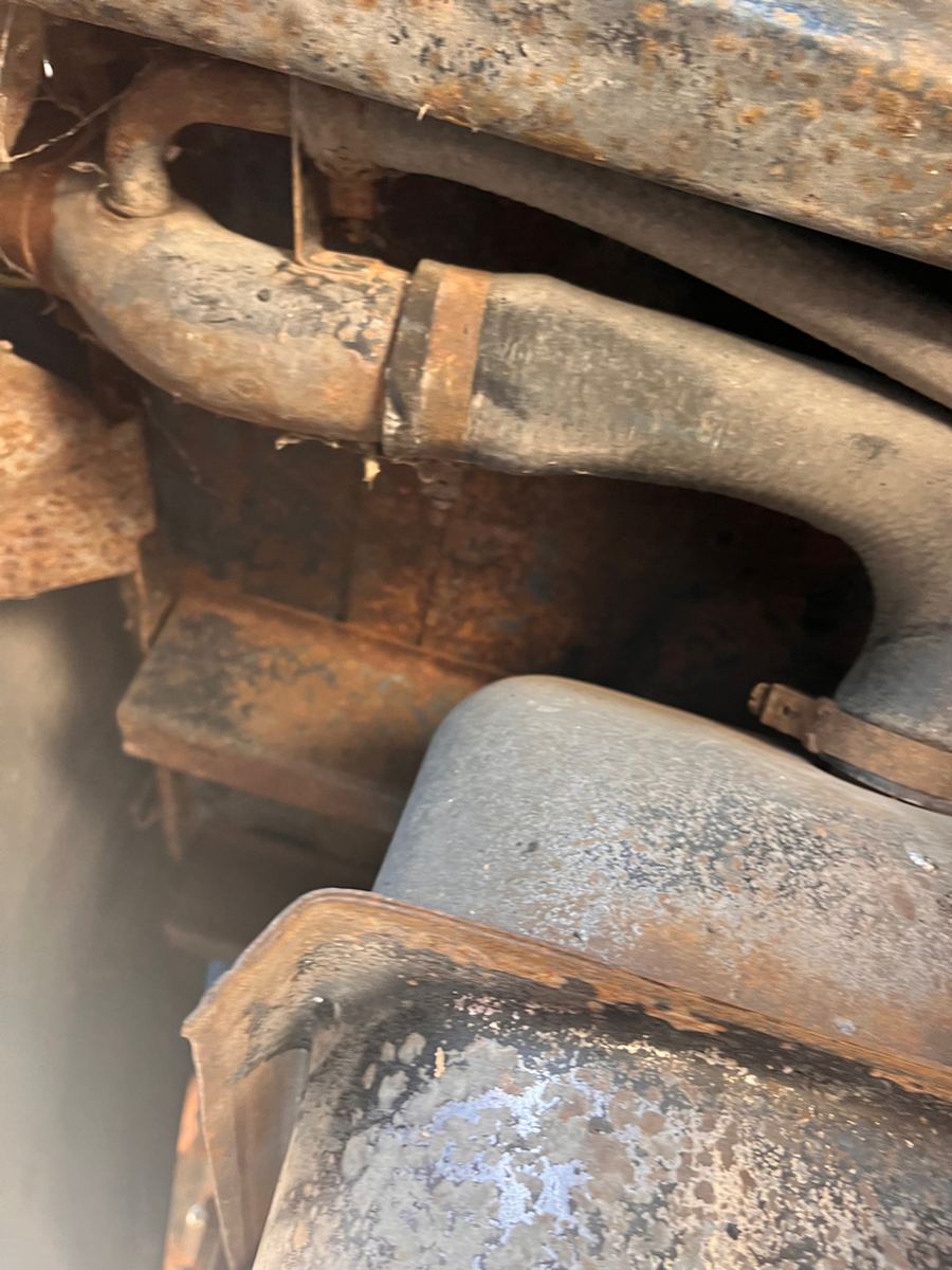 Underbody frame rail with surface corrosion, brake lines running along it