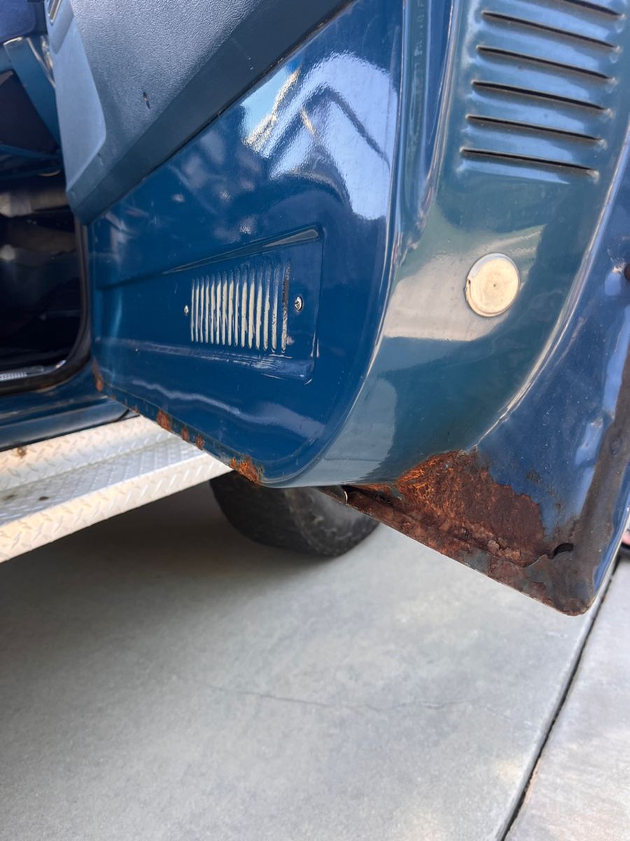 Rust along the lower rocker panel and cab corner of a classic pickup