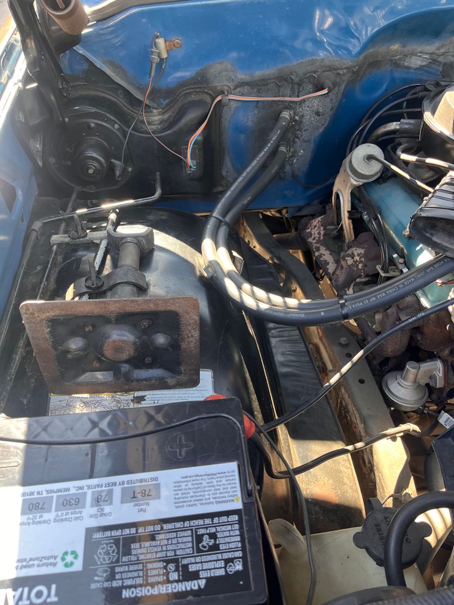 Battery, cables and added wiring in the engine bay of a classic pickup