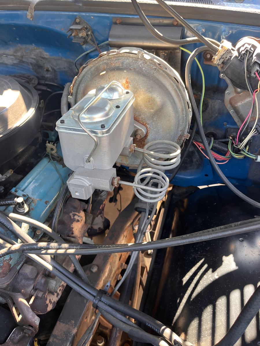 Brake booster and a new master cylinder with coiled brake lines in a classic engine bay