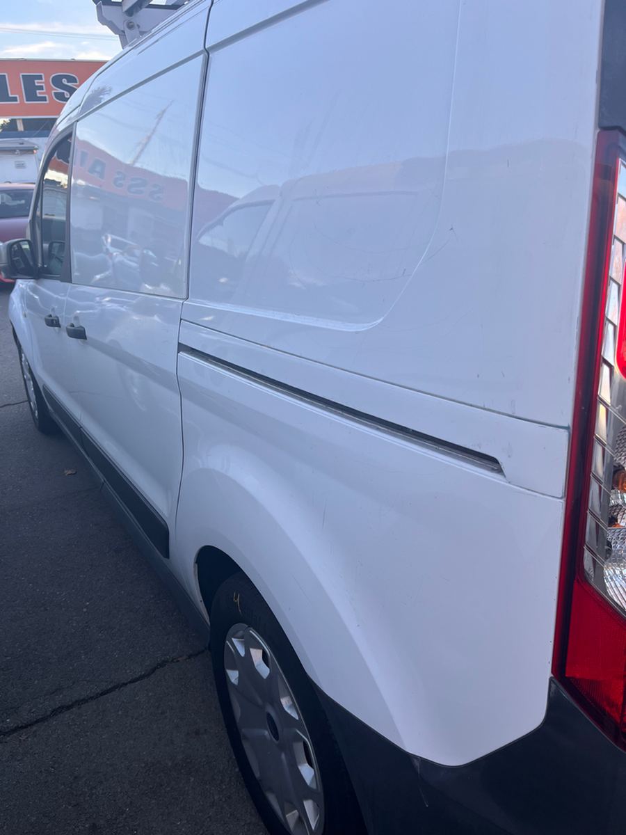 Side profile of a white panel van with a sliding side door