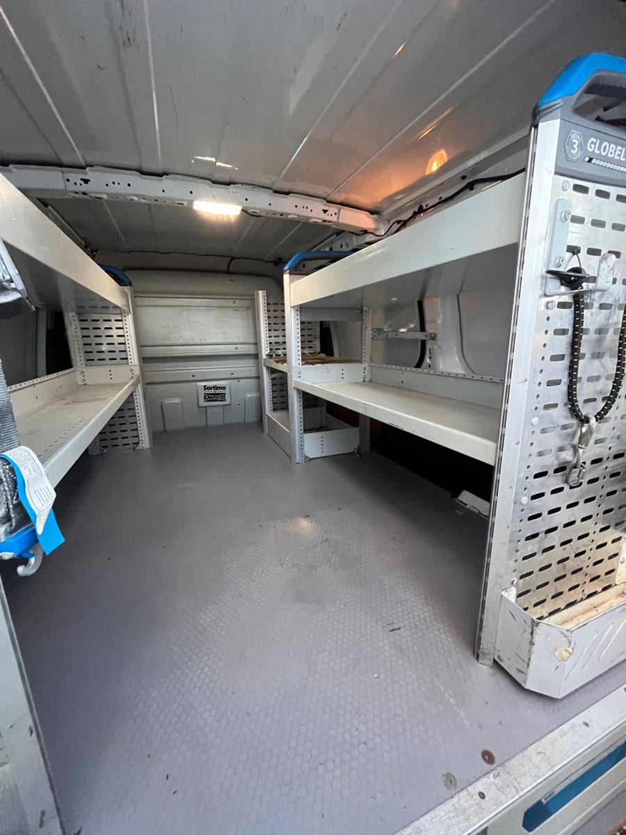 Aluminium shelving racked along the inside wall of a cargo van