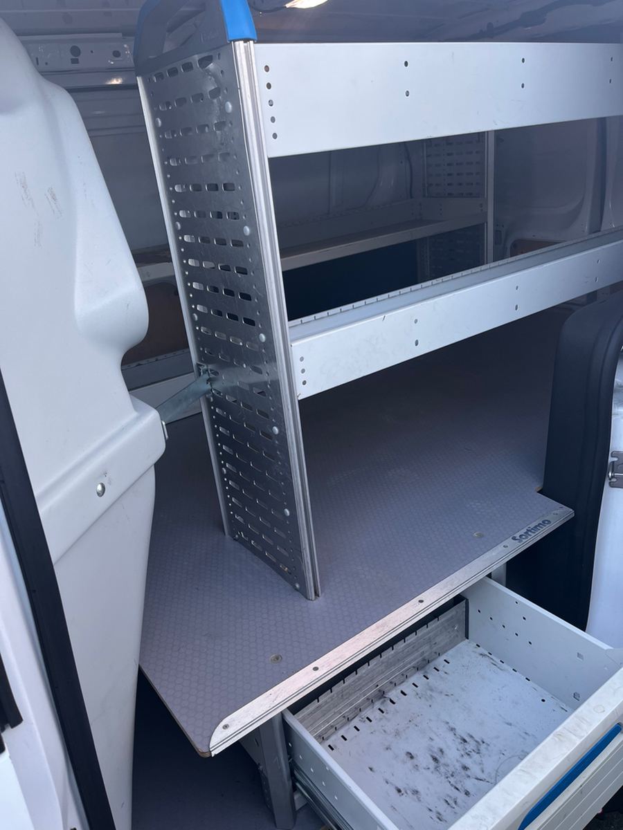 Shelving unit with an open drawer inside a van load area