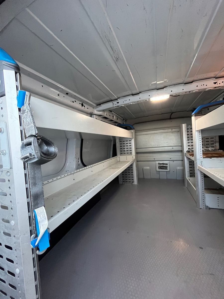 Full length of a cargo van load bay with shelving down one side
