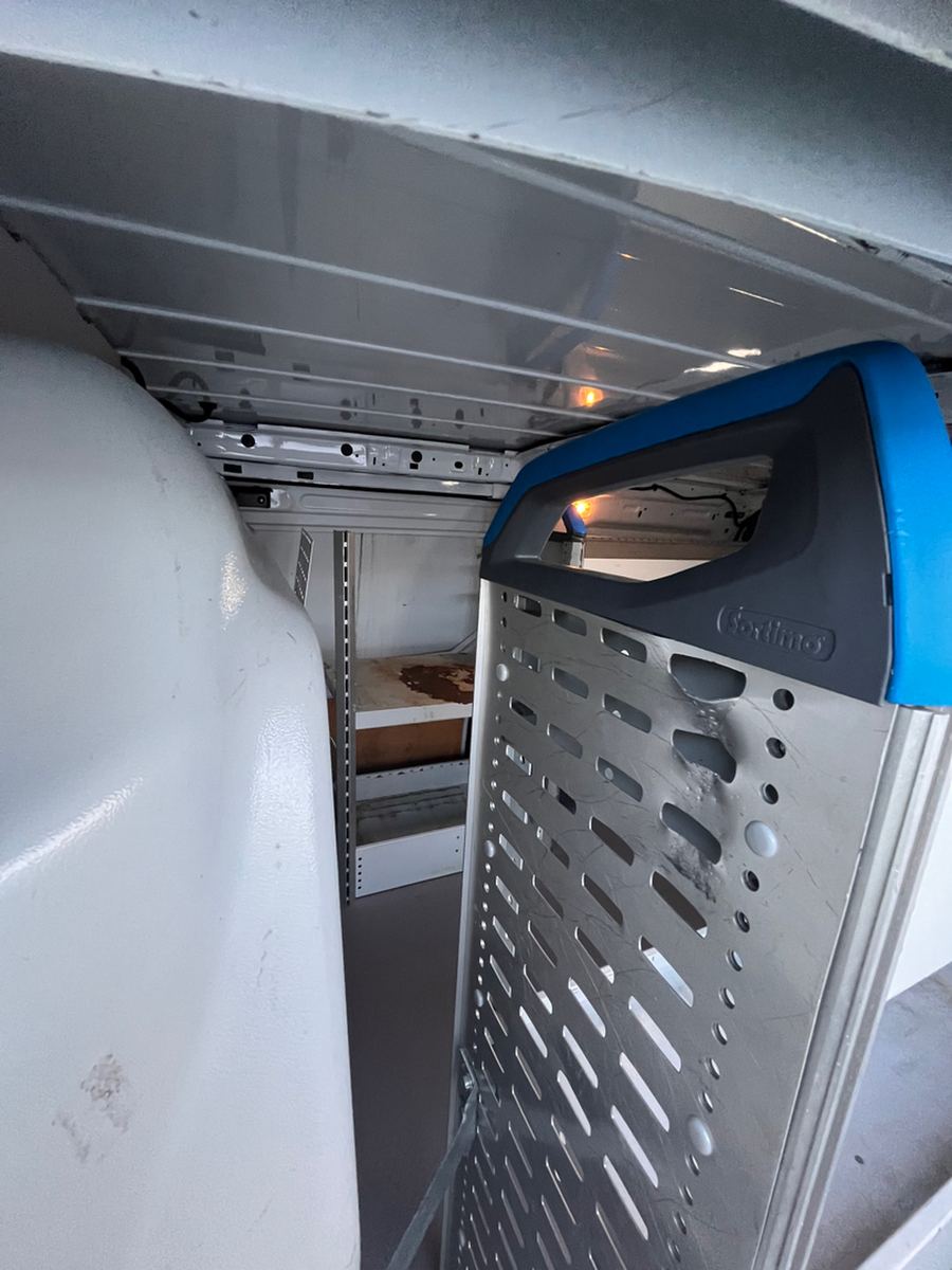 Perforated steel bulkhead partition behind the seats of a cargo van