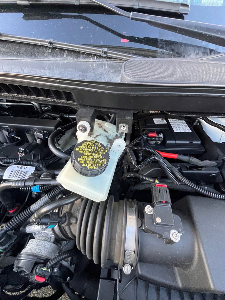 Brake fluid reservoir and intake hose in a van engine bay