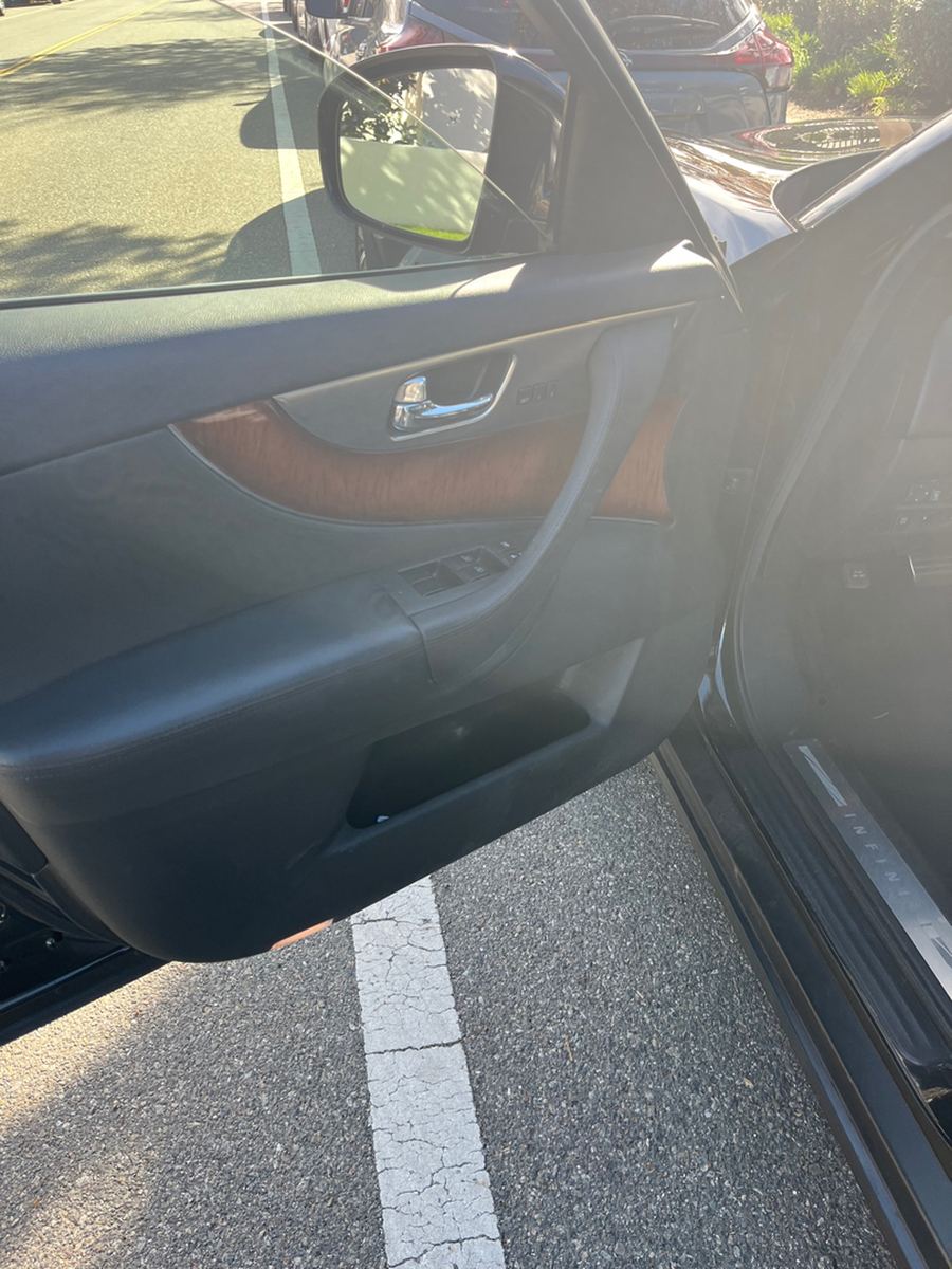 Open driver door of an Infiniti FX35 showing the door card and wood trim