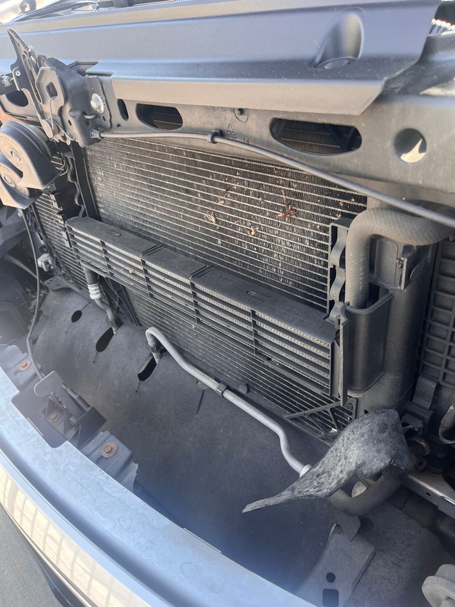 Radiator and air conditioning condenser seen from the front with road debris caught in the fins