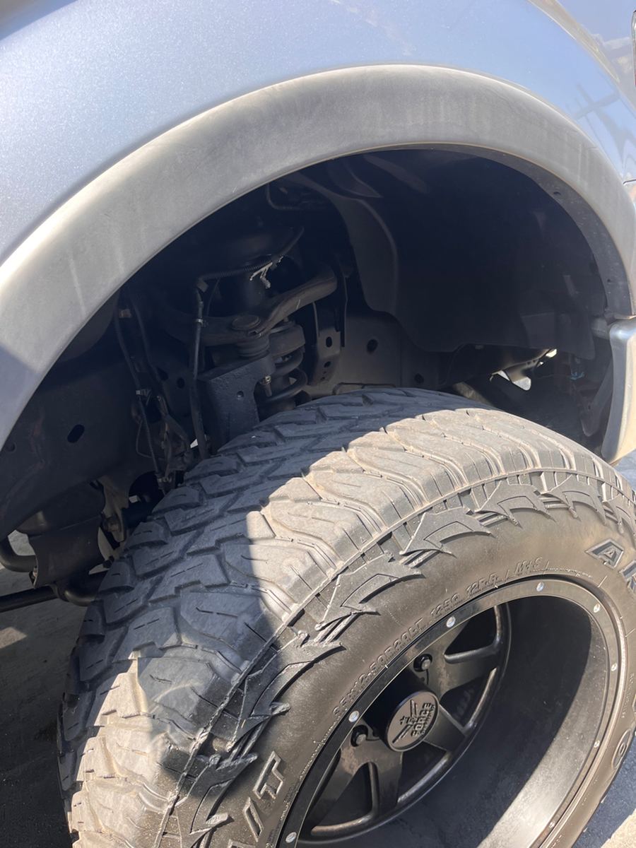 Lifted suspension and all-terrain tire seen inside the front wheel well