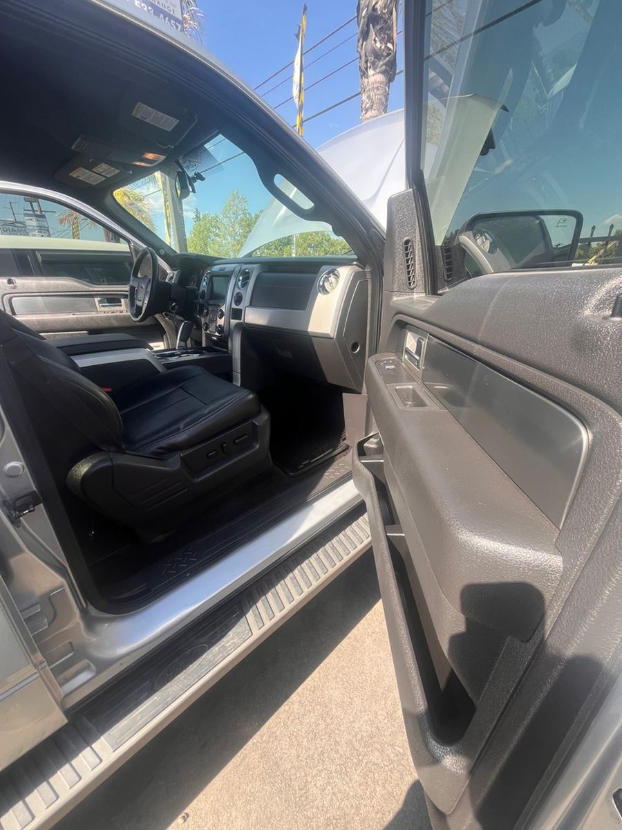 Black leather front seat of a pickup seen through the open driver door