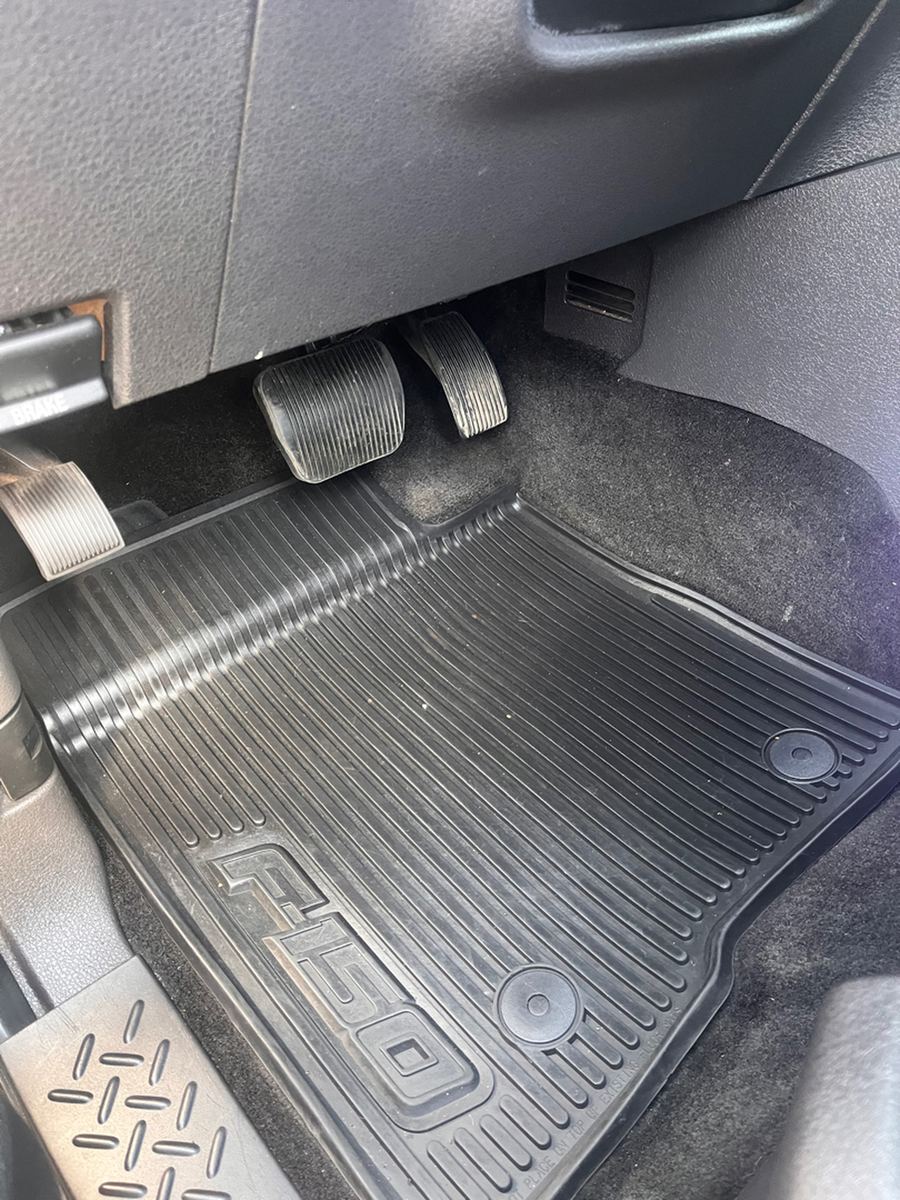 Rubber F-150 floor mat and pedals in the driver footwell