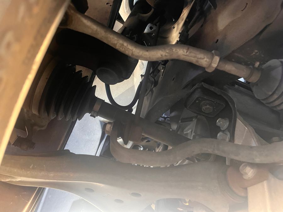 Underbody view of a front subframe, control arm and axle boot