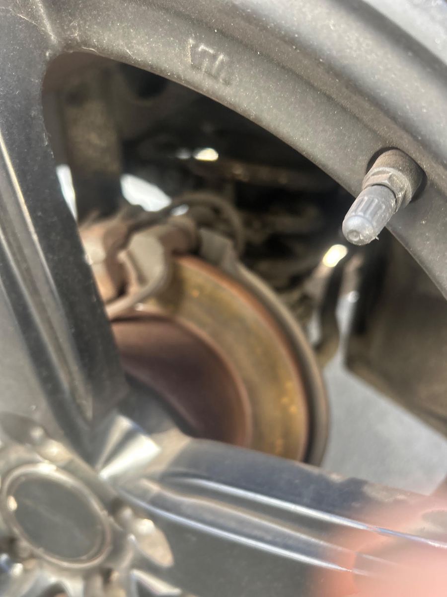 Brake rotor and caliper seen through the spokes of an alloy wheel