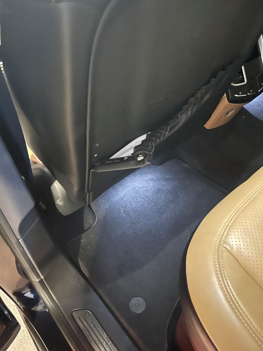 Rear footwell of a Porsche with tan leather seats and dark carpet