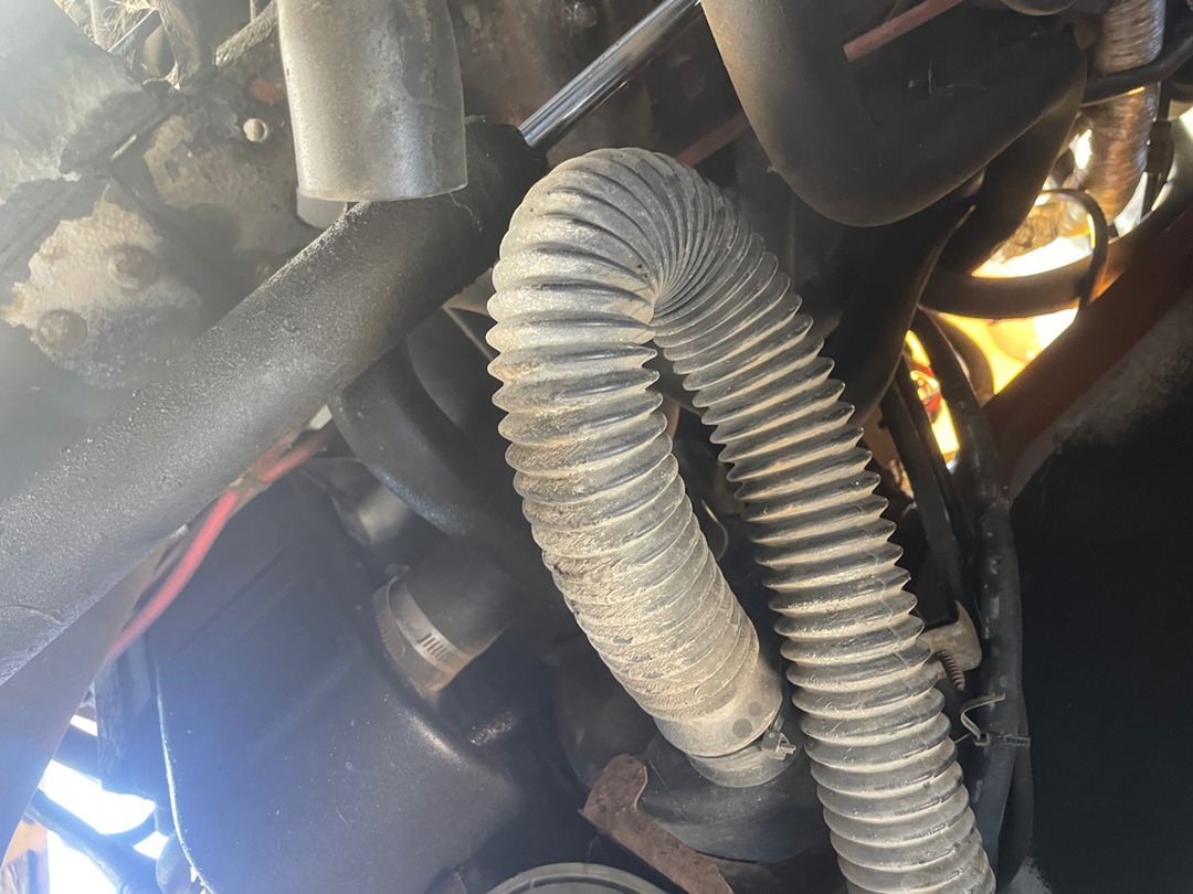 Corrugated air intake hose and aging lines under the chassis of a 1990 Dolphin motorhome