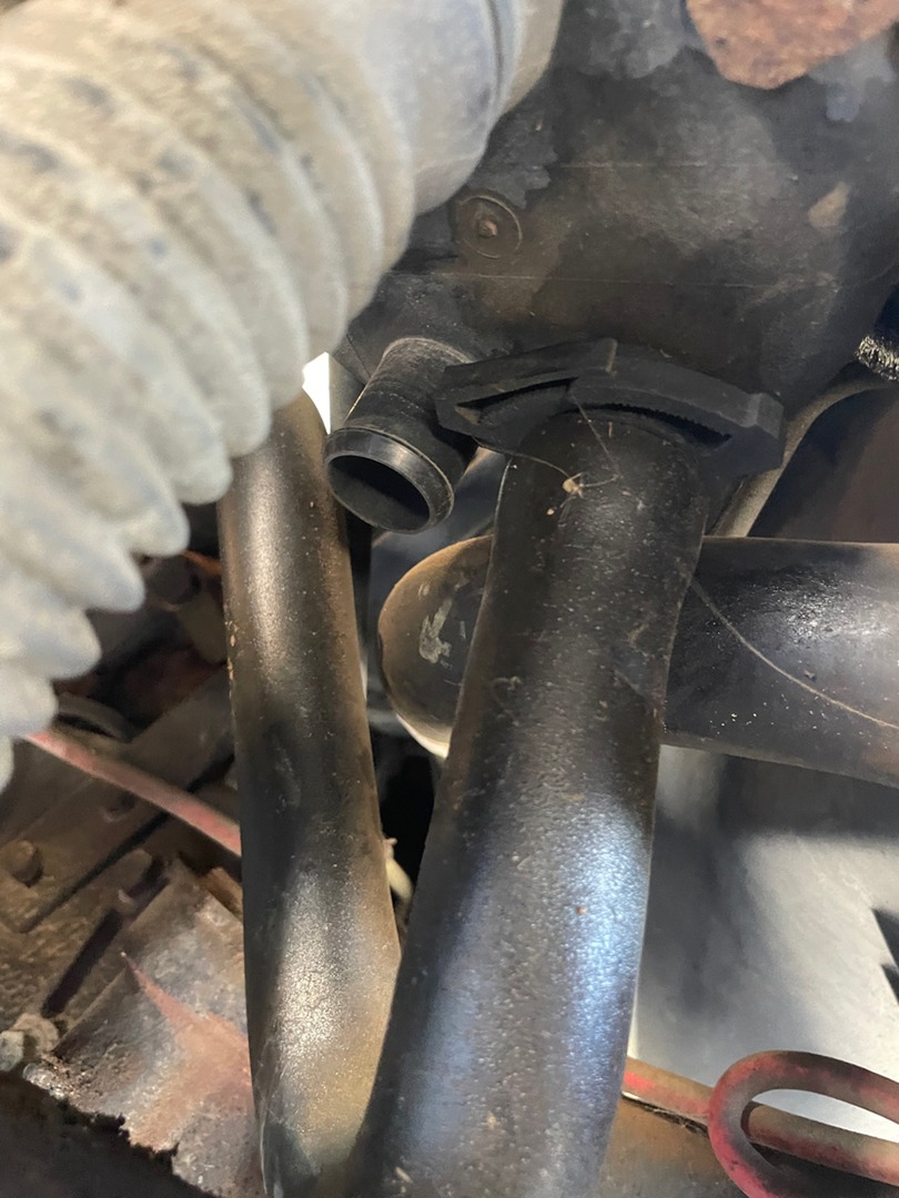 Coolant and heater pipes with a snapped plastic fitting on an older motorhome engine