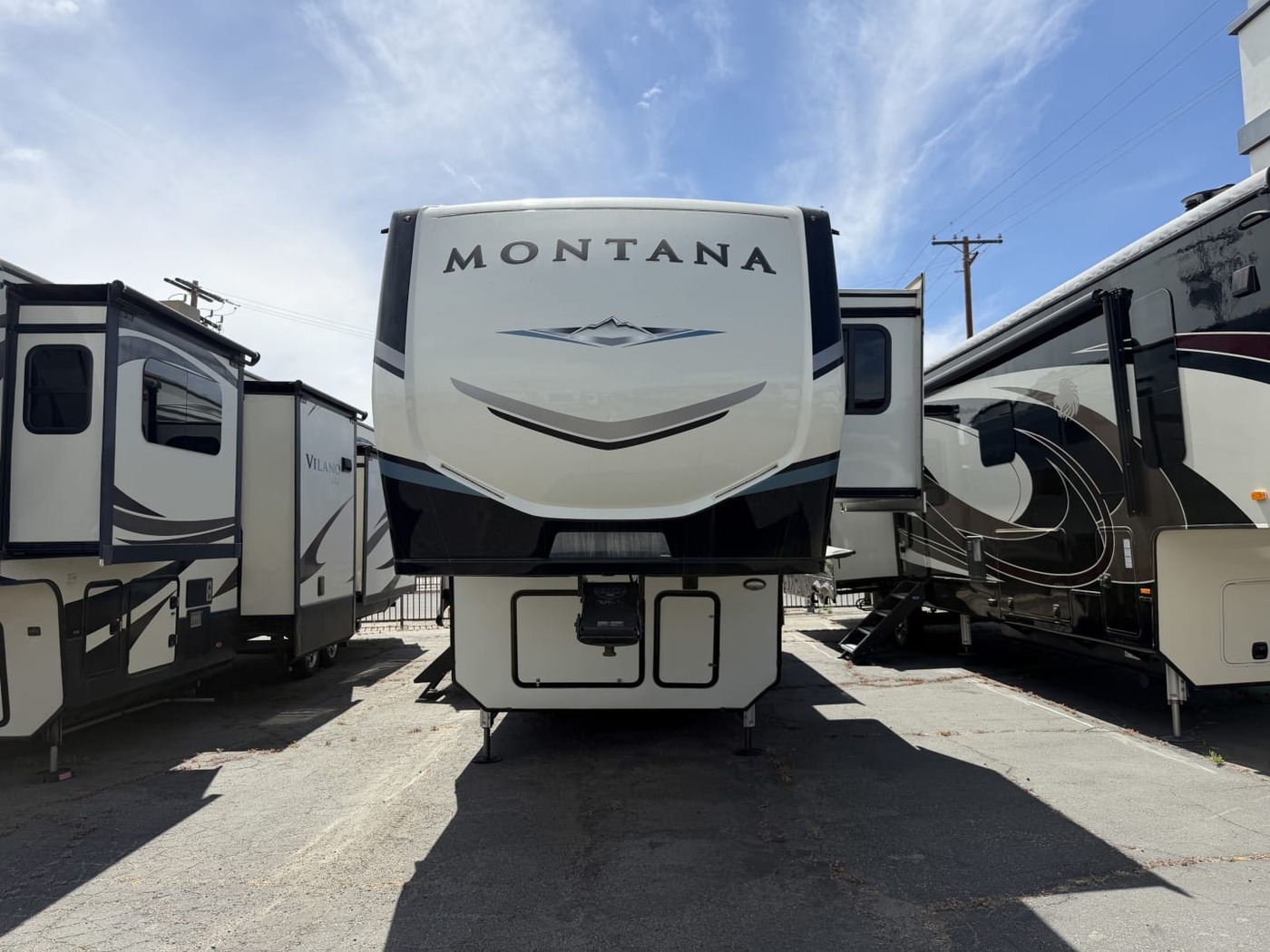 Front cap of a Keystone Montana fifth-wheel trailer on a lot between other fifth wheels