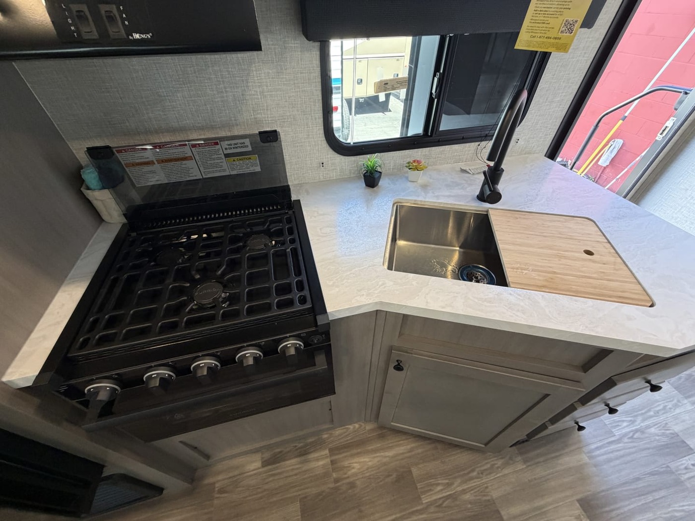 Gas cooktop and stainless sink in a travel trailer kitchen