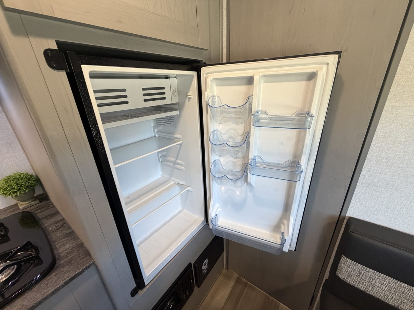 Open refrigerator with empty shelves in a small travel trailer