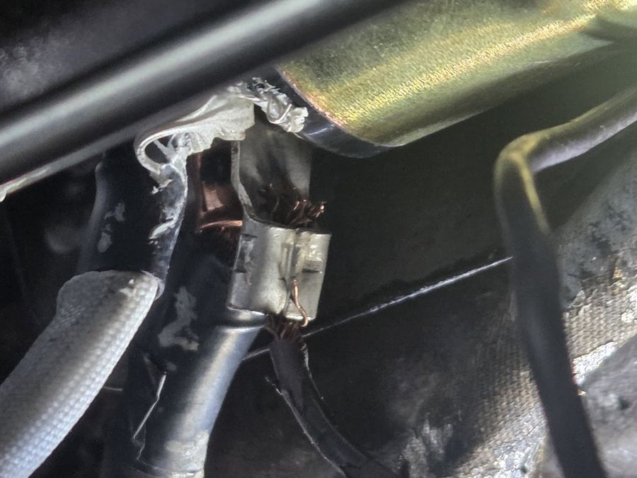 Close-up of a starter motor and its wiring in an engine bay