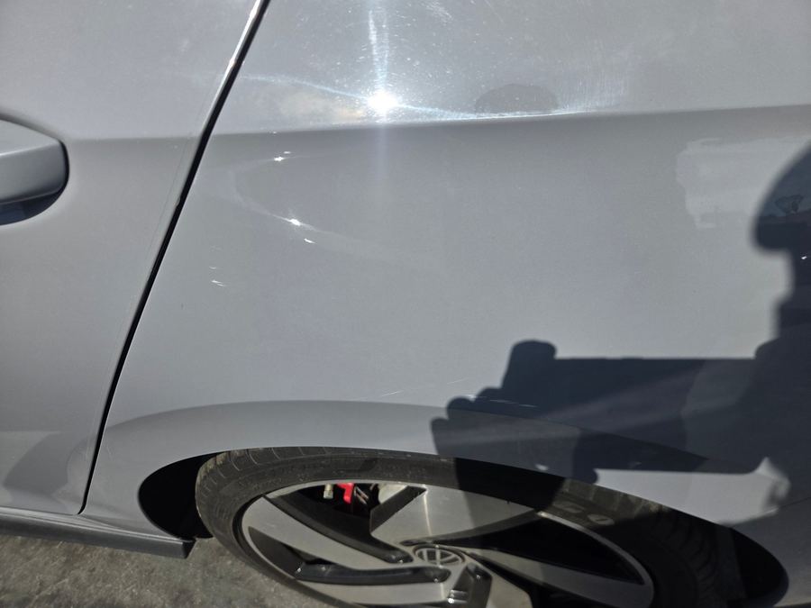 Small dent and scuff on the rear door of a silver hatchback