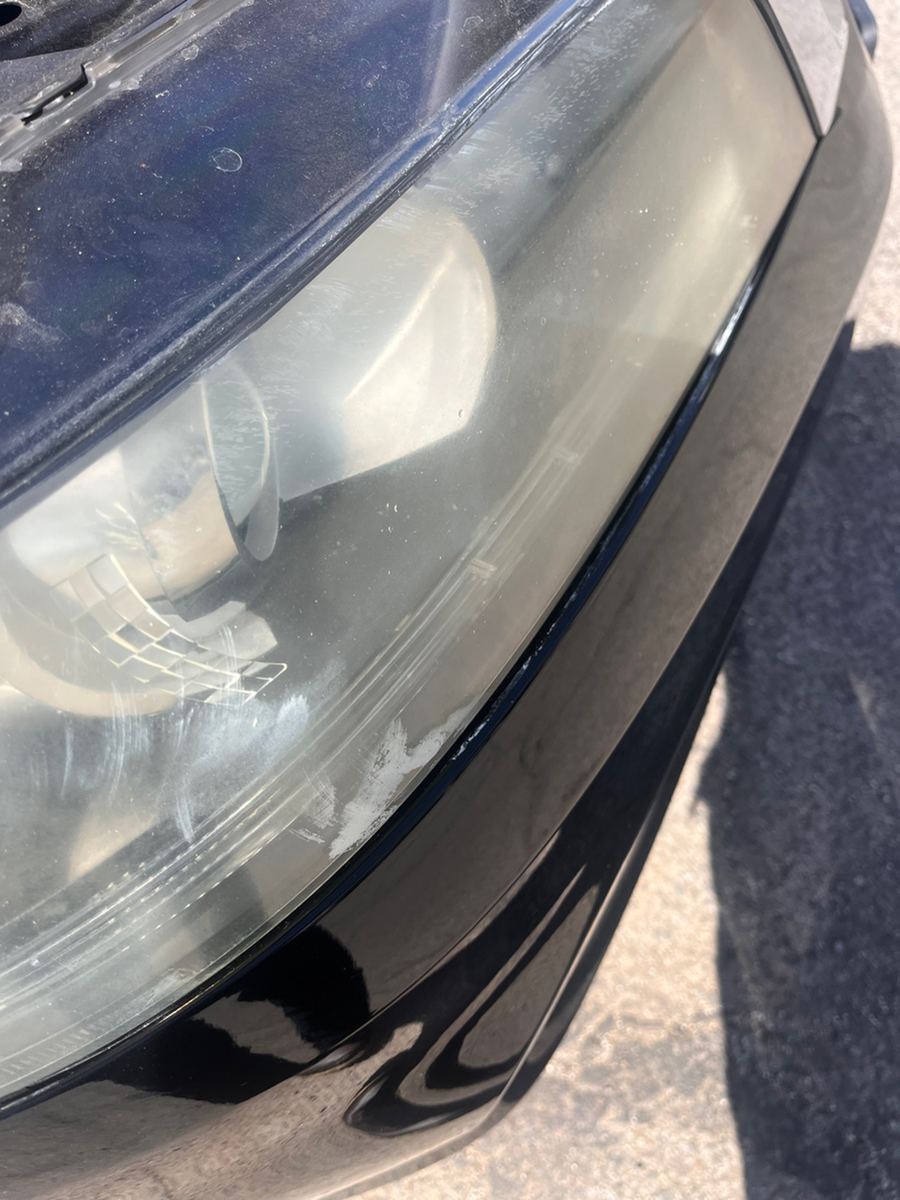 Hazed, yellowed headlight lens on a black Honda Accord