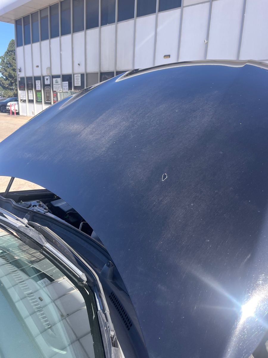 Chipped paint along the front edge of a black hood