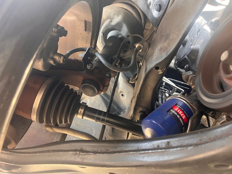 CV axle boot and oil filter seen from underneath a car