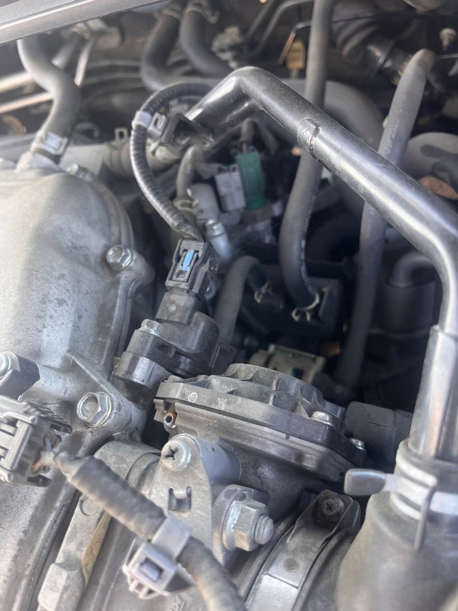 Top of a four-cylinder engine with the intake and wiring in view
