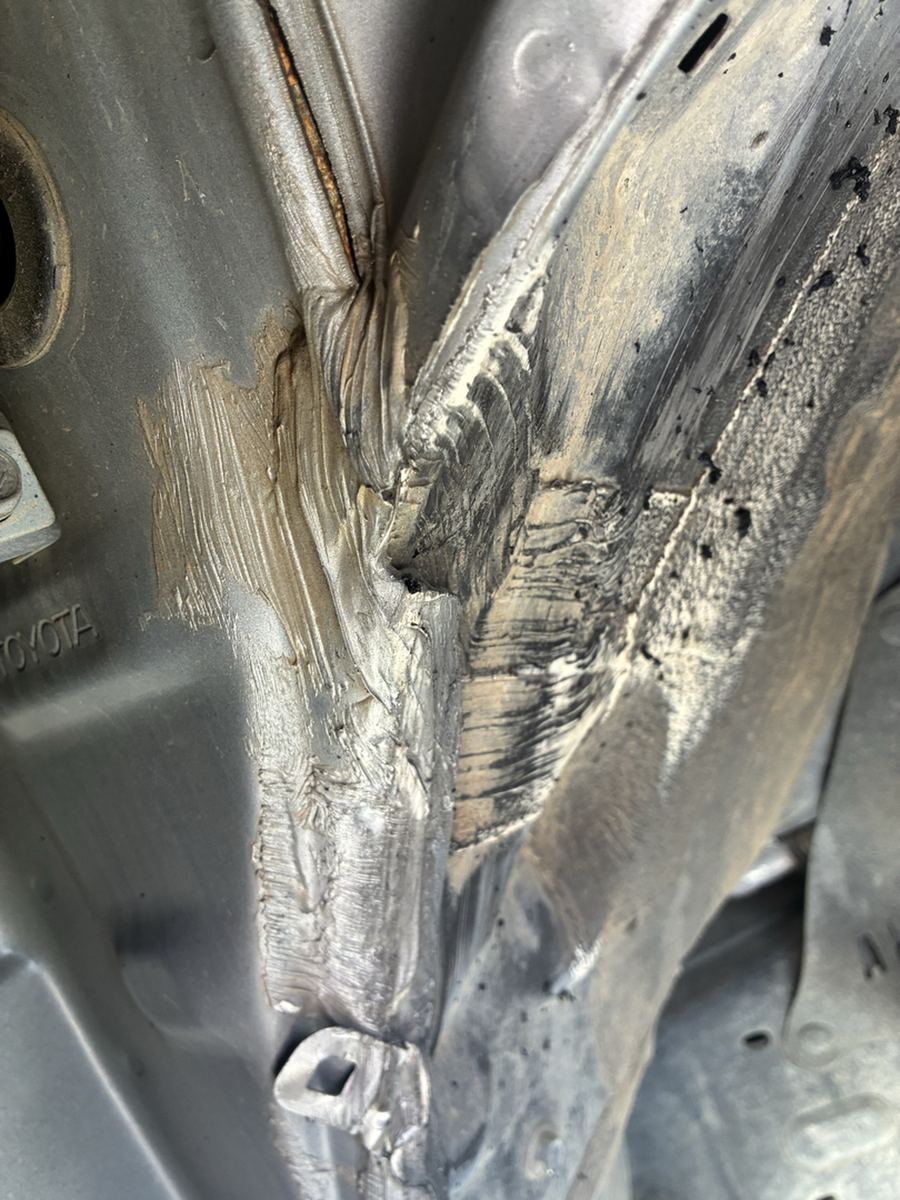 Corroded metal breaking away in sheets at a truck cab mount