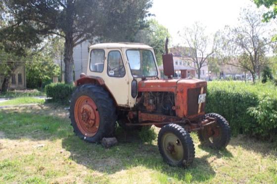Red farm tractor parked in a yard