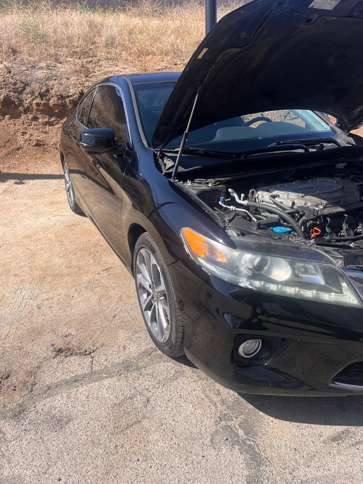 Black Honda Accord coupe with its hood raised, seen from the front corner