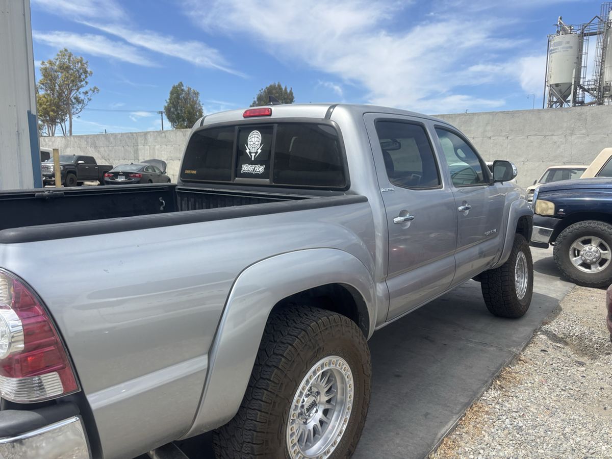 Silver 2014 Toyota Tacoma double cab photographed from the rear corner